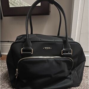 Small black TUMI travel hand bagpre-owned in good condition zippers work good!
